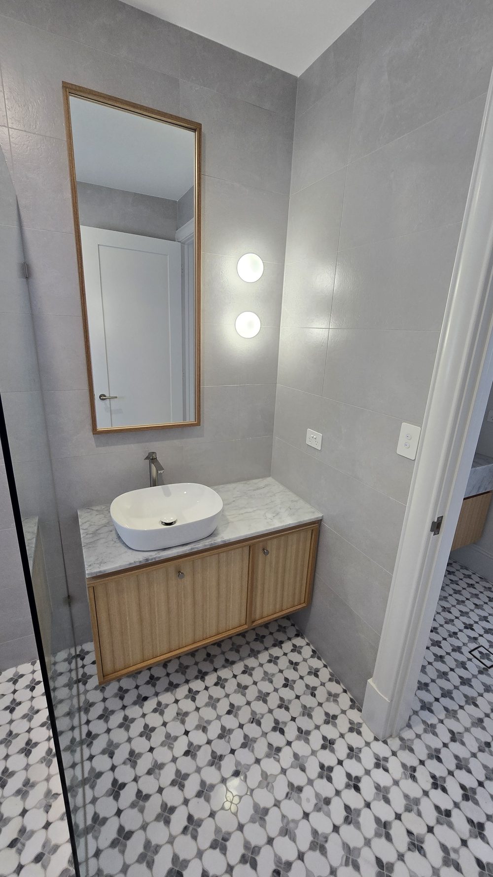 Bathroom with patterned tiles and a walk-in shower