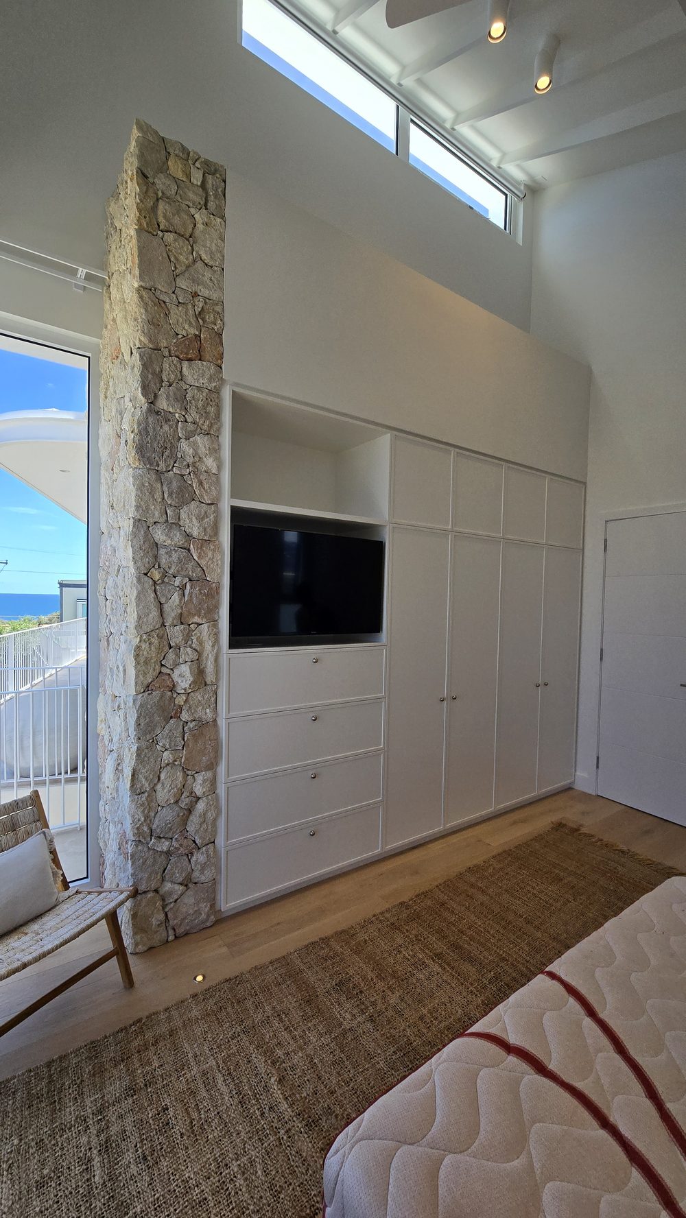 Bedroom built-in storage and feature wall with stone detailing