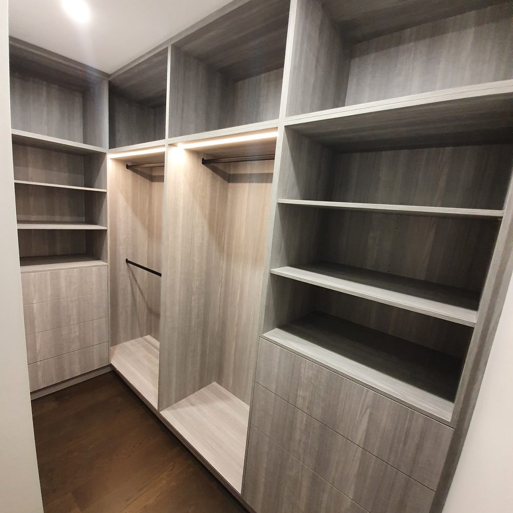 Timber-lined walk-in wardrobe with custom shelving