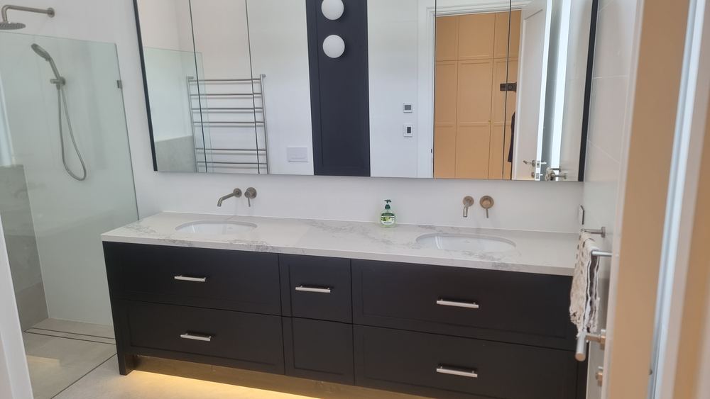Black double vanity with twin basins and wall-hung cabinetry