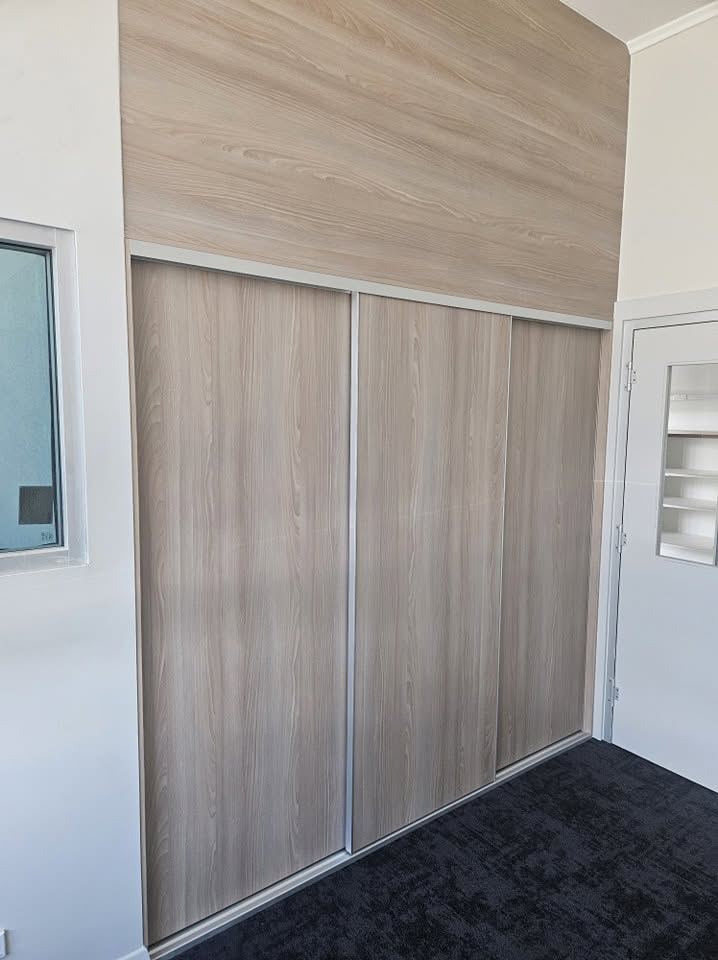 Timber-look sliding wardrobe doors in a carpeted bedroom