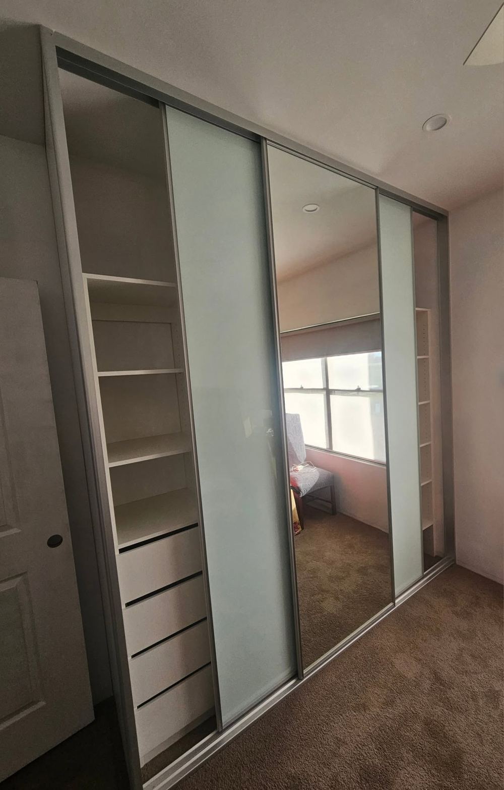 Frosted-glass and mirror sliding wardrobe with white internal shelving