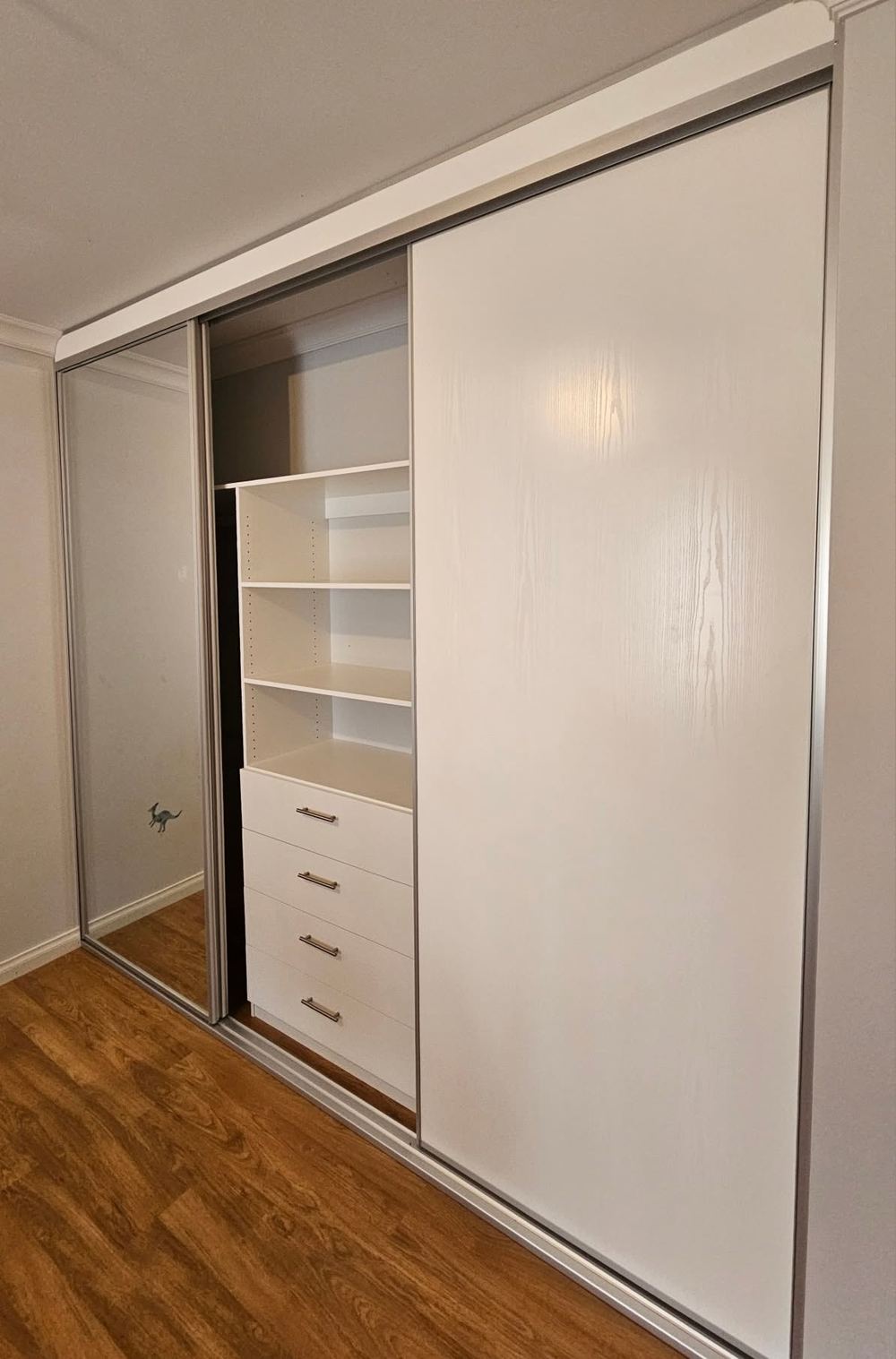 White sliding wardrobe with an internal drawer bank and adjustable shelving