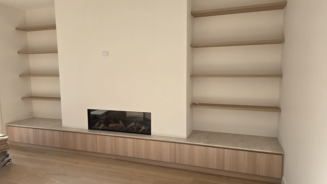 Arched built-in shelving and custom cabinetry surrounding a fireplace