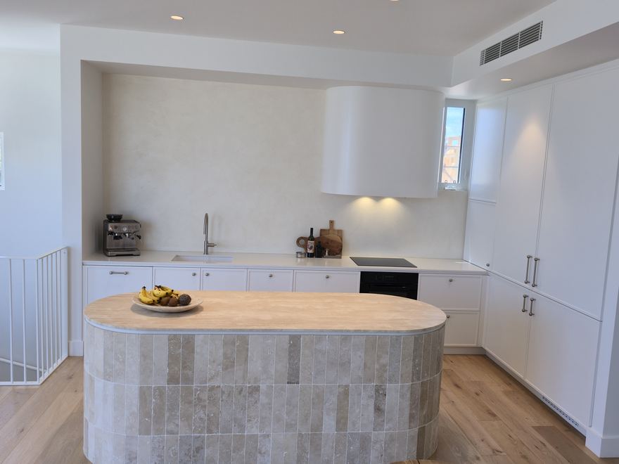 White kitchen island with stone benchtop and brushed hardware